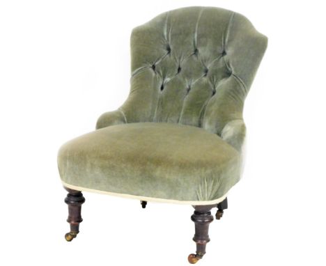 A late Victorian mahogany framed button back nursing chair, overstuffed in green to the back and seat, on turned front legs t