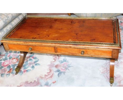 A late Regency mahogany sofa table, with a brass galleried top above two frieze drawers, raised on out swept legs, united by 