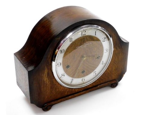 A Pleasance &amp; Harper Ltd of Oxford Art Deco style oak cased mantel clock, with a scroll carve base and battery operated m
