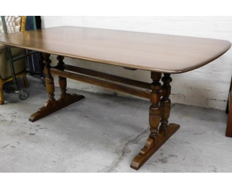 A light beech and elm Ercol dining table, on two splay baluster columns, 73cm high, 176cm wide, 98cm deep 