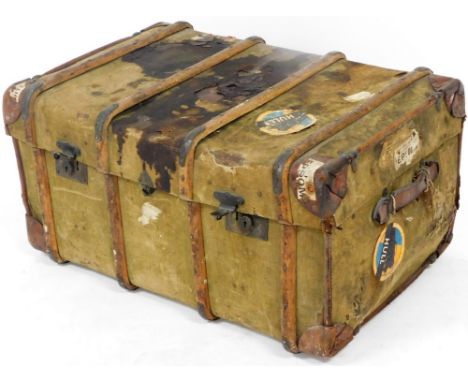 An early 20thC pressed wooden bound travel trunk, with various labels to include Epsom, Hull, etc., metal mounts and leather 