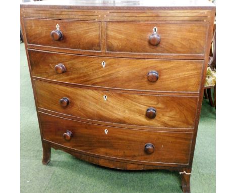 A George III mahogany bow front chest of two short and three long drawers, with fret work marquetry banded cornice, with turn