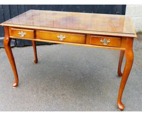 A late 20thC polished oak console table, with glass cover top above three drawers on flared legs, 77cm high, 121cm wide, 61cm