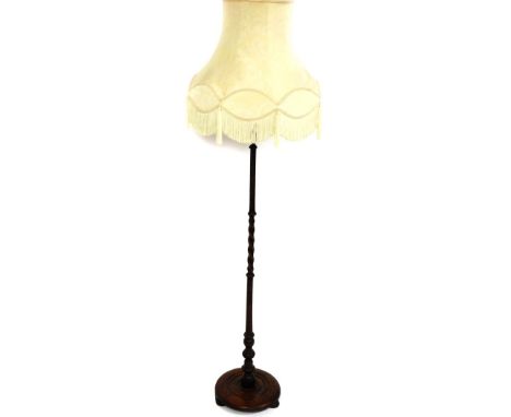 A mid 20thC oak standard lamp, of baluster and barley twist stem, on a circular base, terminating in compressed bun feet, wit