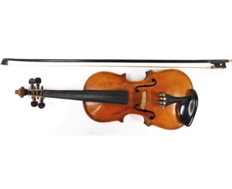 A late 19thC two piece back violin and bow, the violin unmarked in walnut casing, together with a bow with mother of pearl in