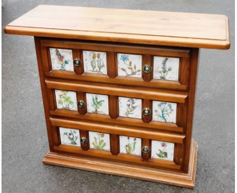 A pine novelty cabinet, the elongated rectangular top above three drawers each set with four ceramic floral panel designs, on