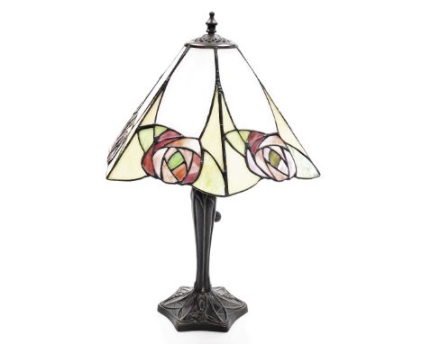 A Tiffany style table lamp, the metal base in the Art Nouveau style, with an eight point rose design shade, on a black metal 