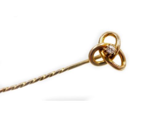 A knot design stick pin, set with single tiny diamond in claw setting with three tier knot on pleated stem, 6cm high, the hea