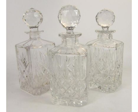 A pair of square cut glass whisky decanters and stoppers, 25cm high, and a Royal County decanter and stopper, (3).