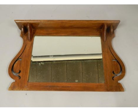 An Art Nouveau oak overmantel mirror, with a shelf top, 105.5cm x 15.5cm x 68.5cm.