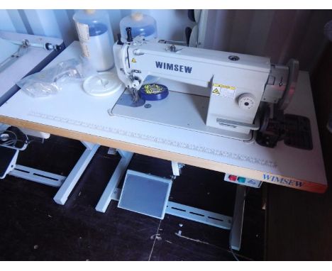 A Wimsew W-3300 electric sewing machine, treadle table and attachments.