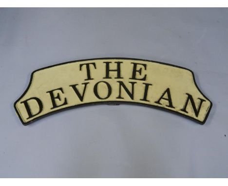 A cast metal and enamel replica train headboard The Devonian, BR (M) Western Region, 91cm long.