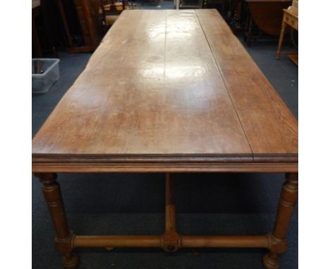 A rectangular pine refectory table, raised on turned legs and bun feet, united by an X frame stretcher, 382cm x 125cm x 75cm.