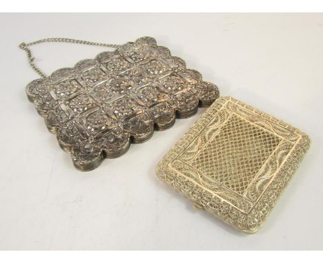 An Indian white metal filigree cigarette case, 10cm x 8cm, and an Egyptian white metal hand mirror with embossed floral decor