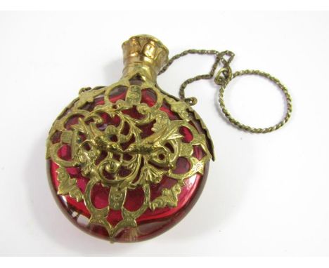 A Victorian cranberry glass scent bottle, of compressed circular form, with gilt overlay decorated with birds, leaves and fol