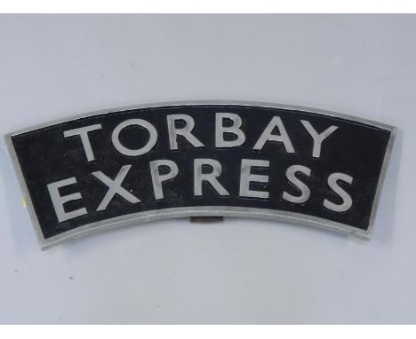 A cast metal and enamel replica train headboard Torbay Express, 68cm long.