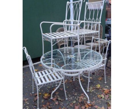 A cream painted circular cast iron garden table, with glass top, and four chairs, (5).