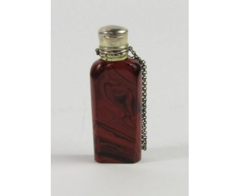 A late 19thC Continental red agate glass scent bottle, clear stopper, with a white metal hinged lid and safety chain, 7cm lon