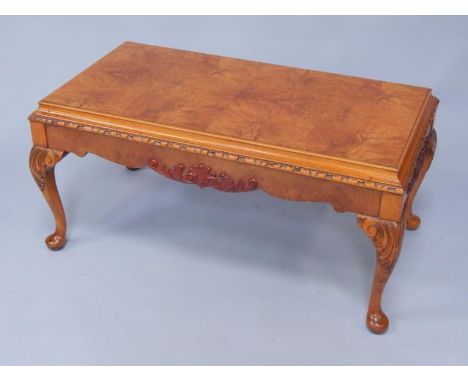 A walnut rectangular occasional table with a burr top, carved leaf moulding to the sides, raised on cabriole legs, 96cm x 51c