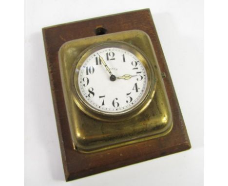 An early 20thC French brass cased wall mounted bedroom clock, enamel dial bearing Arabic numerals, eight day movement.