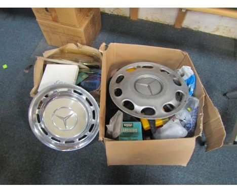 A collection of automobile accessories, including Mercedes Benz badges, wheel trims, first aid kit and after market trim, cha