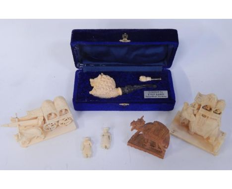 An Indian 19thC ivory carving of an elephant with figures in a howdah, another carving of buffalo pulling a carriage, wooden 