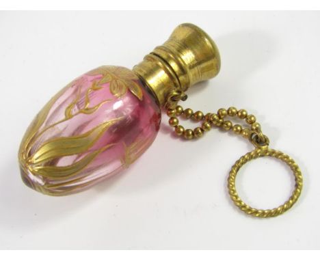 A late 19thC Continental pink glass scent bottle, of ovoid form gilt decorated with flowers, gilt mount, hinged lid and chain