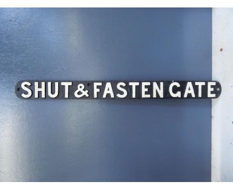 A cast Shut and Fasten Gate sign, 7.5cm high, 84cm wide.