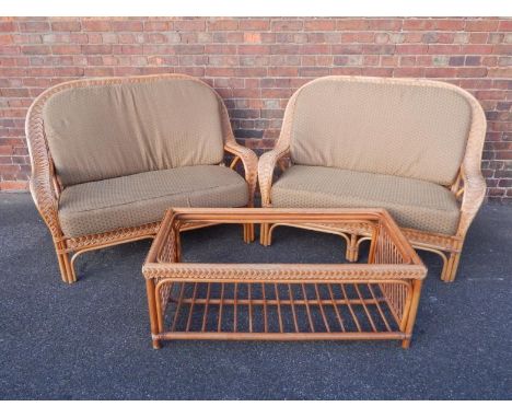 A cane conservatory suite, comprising pair of two seater sofas with coffee table, (3).