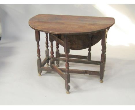 An 18thC oak gateleg dining table, raised on baluster turned supports united by stretchers, 99cm long, 33cm wide, 121cm fully