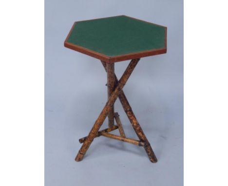 An hexagonal occasional table, raised on three crossed bamboo legs, 64cm high.