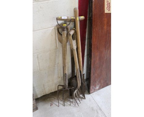 A quantity of wooden handled vintage gardening tools, including forks, spades and a slasher