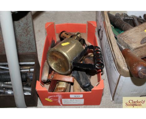 A box containing various scrapers, knives and a brass blow lamp