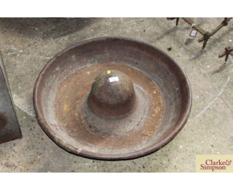A cast iron circular pig trough