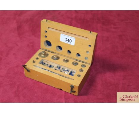 A cased set of chemist scale weights complete with tweezers