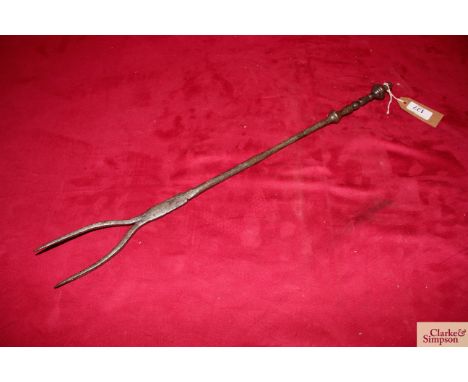 A 18th Century wrought metal twin pronged down hearth flesh fork