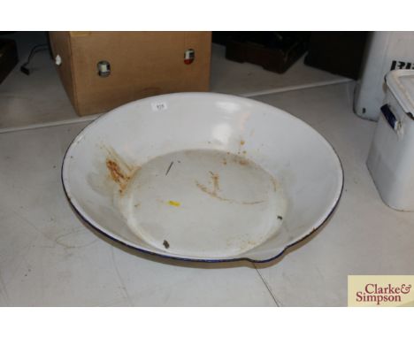 A large white enamel skimming pan