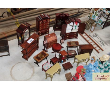 A quantity of dolls house furniture to include a glazed display cabinet, chest on chest, cabriole legged bookcase, linen pres