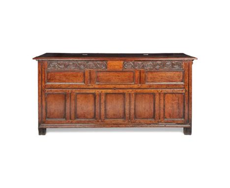 LARGE OAK JOINED CHEST 17TH CENTURY the hinged top opening to a void interior, above a foliate carved frieze and three-over-f