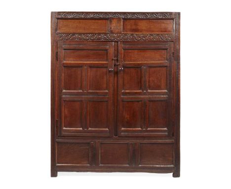 OAK CUPBOARD, WESTMORELAND LATE 17TH CENTURY the twin panel frieze framed by carved flower heads and scrolling leaf motifs an