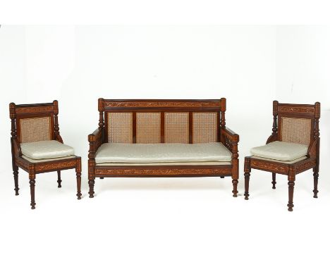 AN INDIAN CARVED ROSEWOOD THREE PIECE SOFA SET
With a caned back set into four panels, with carved foliate details in relief 