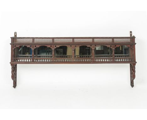 AN INDIAN CARVED WOOD WALL HANGING SHELF With mirrored back and figural supports, latticed top and further reeded supports 70