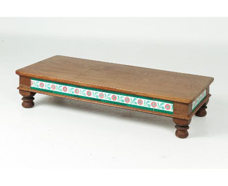 A TILE INSET LOW COFFEE TABLE
Rectangular with foliate tiles to the sides, on bun feet
22cm high x 108cm wide x 50cm deep
Con