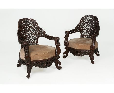 A PAIR OF INDIAN CARVED HARDWOOD ARMCHAIRS
Elaborately carved with birds amongst flowering foliage, with beige upholstery
92c