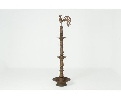 AN INDIAN BRASS OIL LAMP
On a circular base and engraved foliate decoration, with a cockerel topped finial
167cm high
Conditi