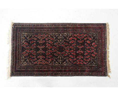 AN ORIENTAL CARPET With a design of boteh motifs within multiple borders on a dark ground 173 long x 90 width cm Condition: S