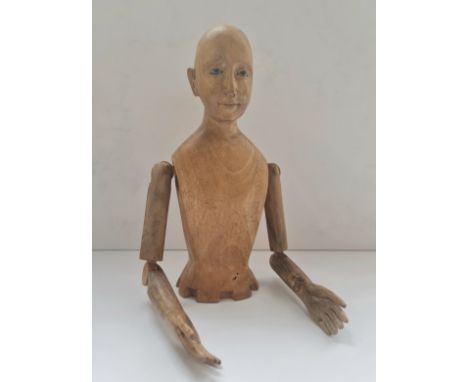 A carved wooden mannequin doll with glass eyes top half height 33 cm.