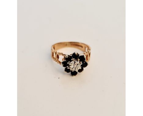 A hallmarked 9ct yellow gold black sapphire cluster ring, with central diamond accent, ring size O, approx. weight 3 gms