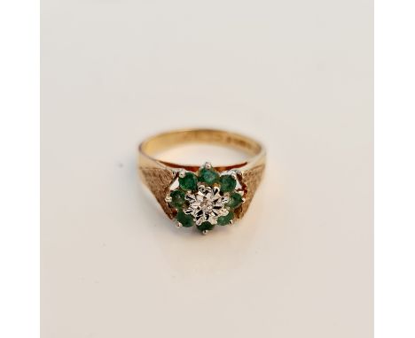 A hallmarked 9ct yellow gold emerald cluster ring with central diamond accent, ring size L, approx. weight 3gms