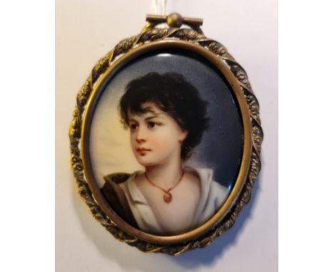 A portrait miniature on ceramic oval of a youth with black hair and open shirt with jewelled necklace in metal oval picture f